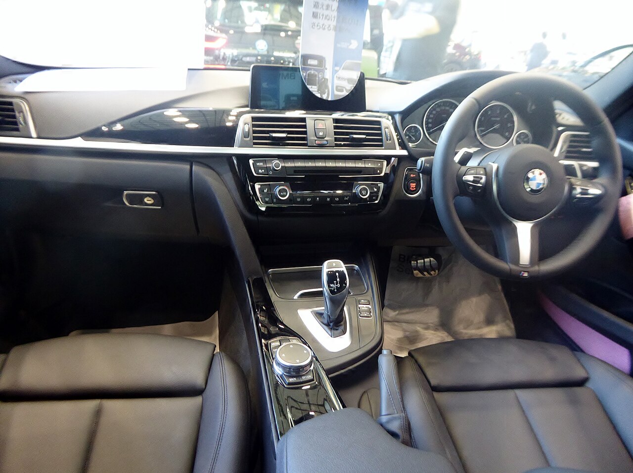 Driver's side interior of a saloon car with leather seats and a centre screen