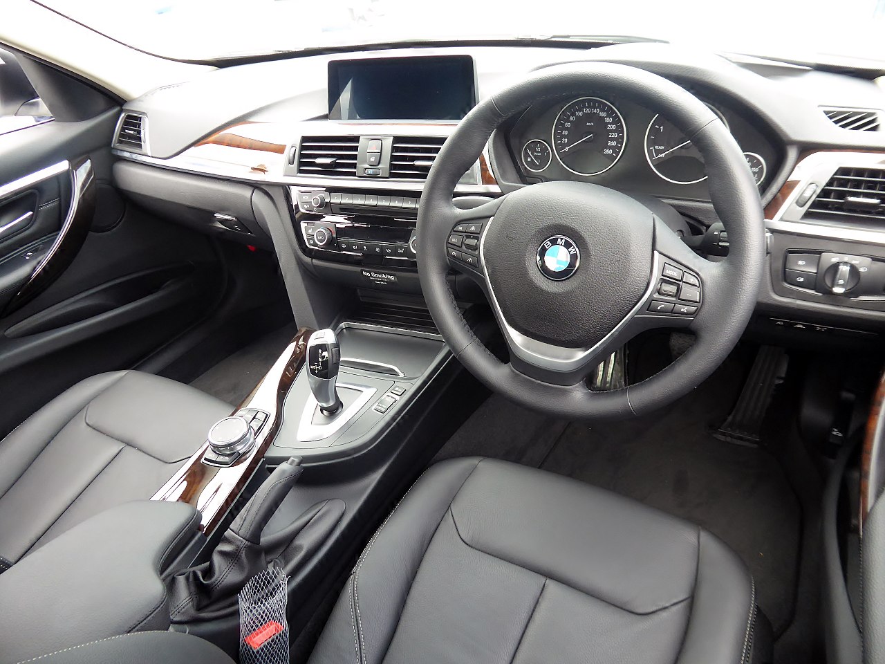 Cabin of an executive saloon with wood trim, dashboard and front seats