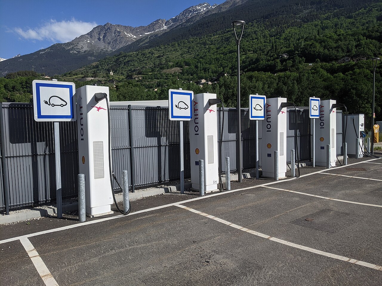 Row of tall rapid charging posts at a French alpine road terminal