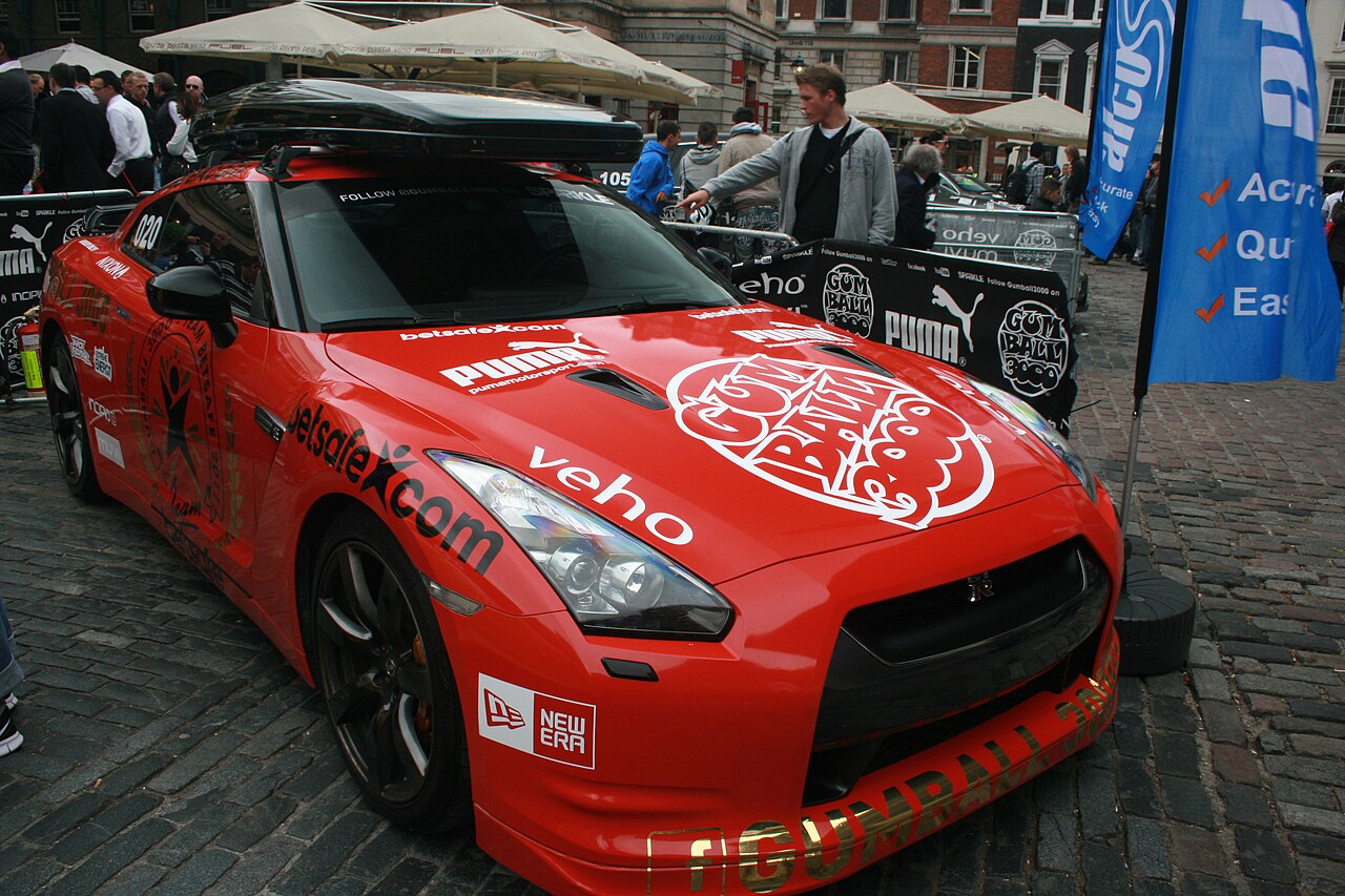 Sports car carrying a long roof box, parked outdoors