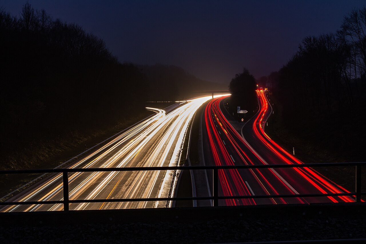 View along a motorway from an overbridge towards an exit slip road