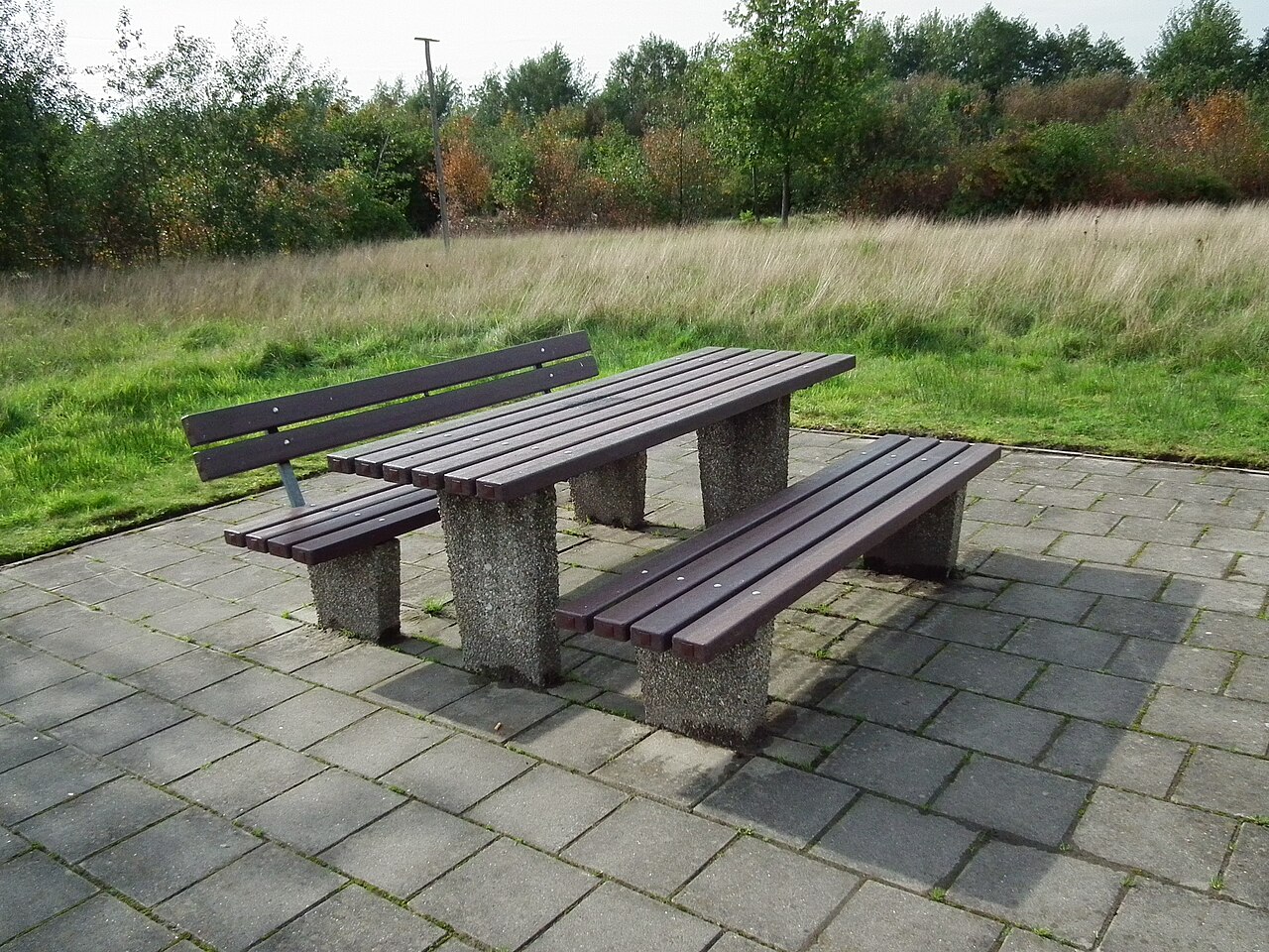 Wooden picnic table and benches at a rest area beside a German motorway
